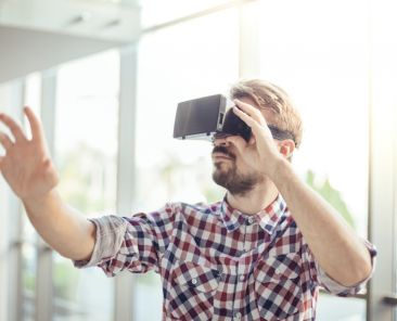 Man wearing a VR headset reaching out with one hand
